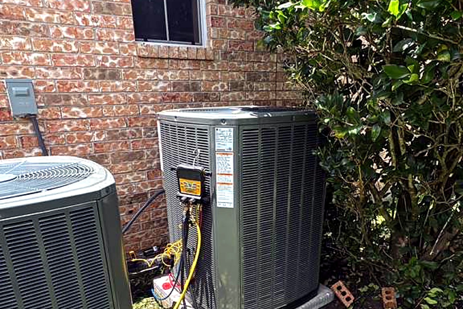 Two Trane condensers being serviced at a Houston home