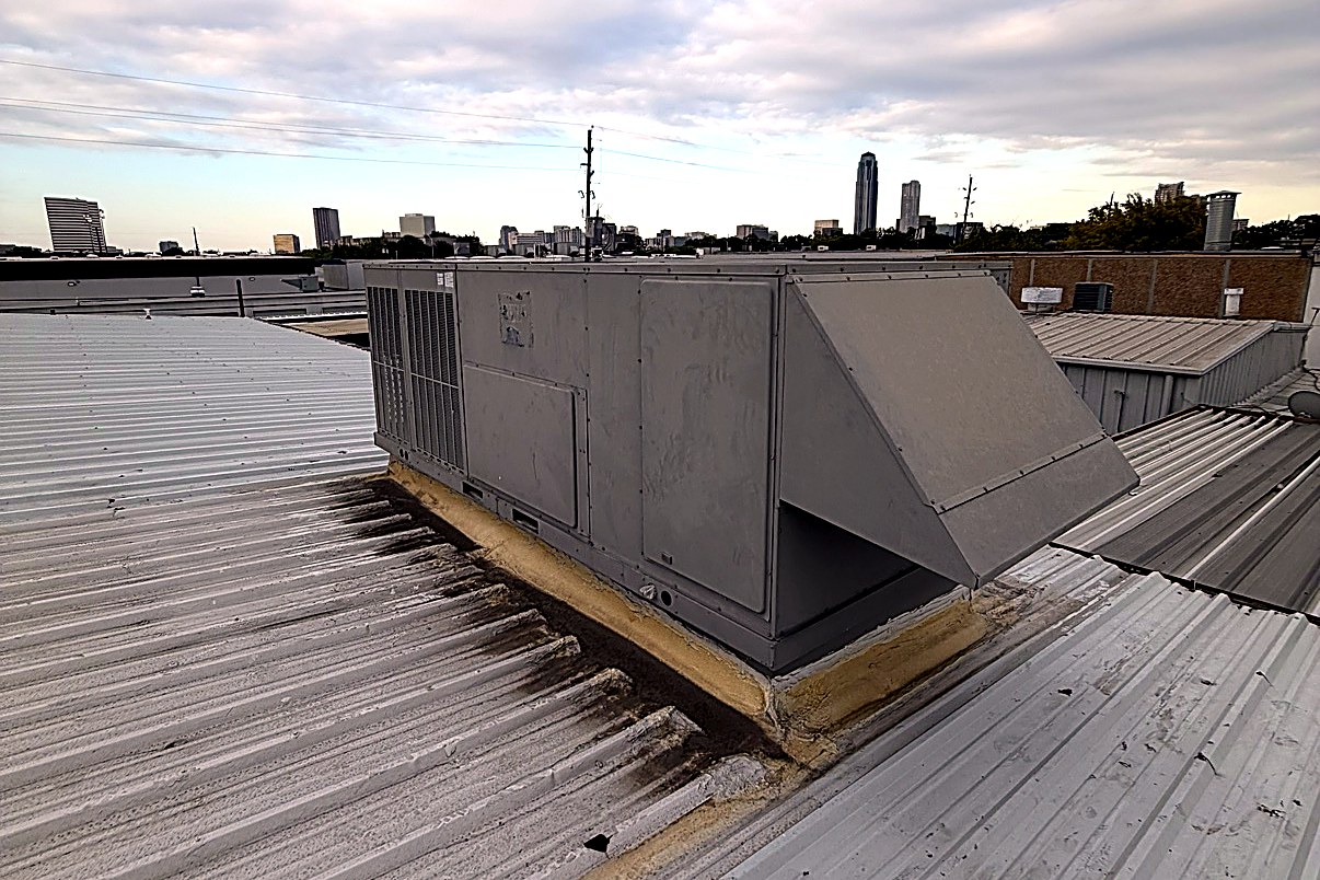 Commercial rooftop packaged unit serviced by Top Texas Choice, Houston skyline behind
